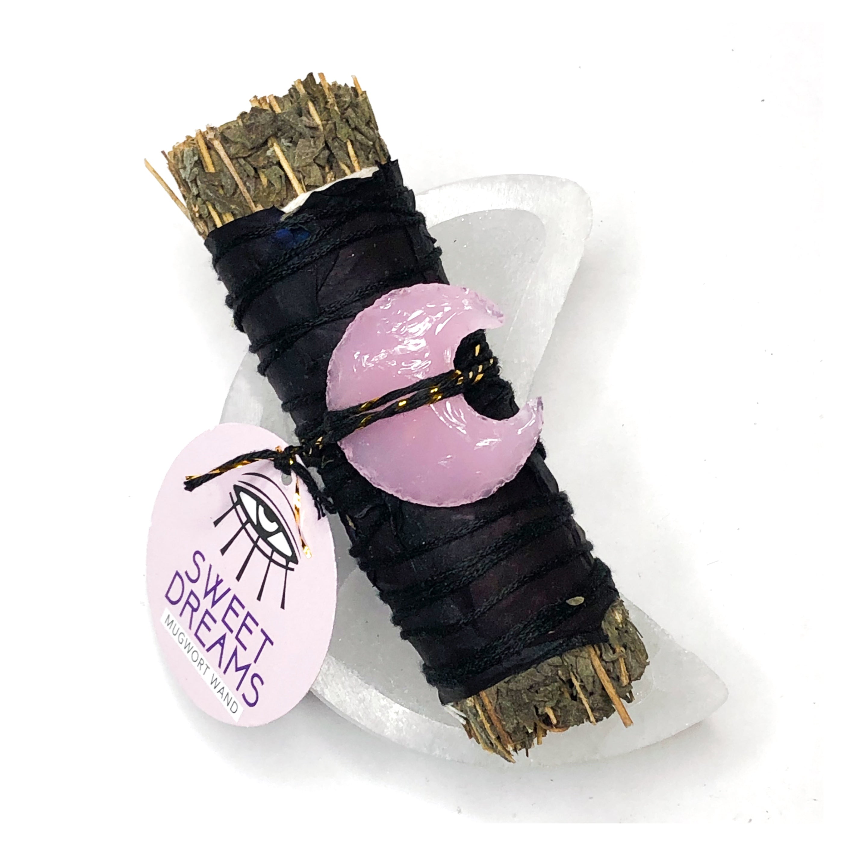 4" mugwort bundle wrapped in black rose petals with a pink crescent shaped moon crystal attached resting in a moon shaped selenite dish enhancing sweet dreams