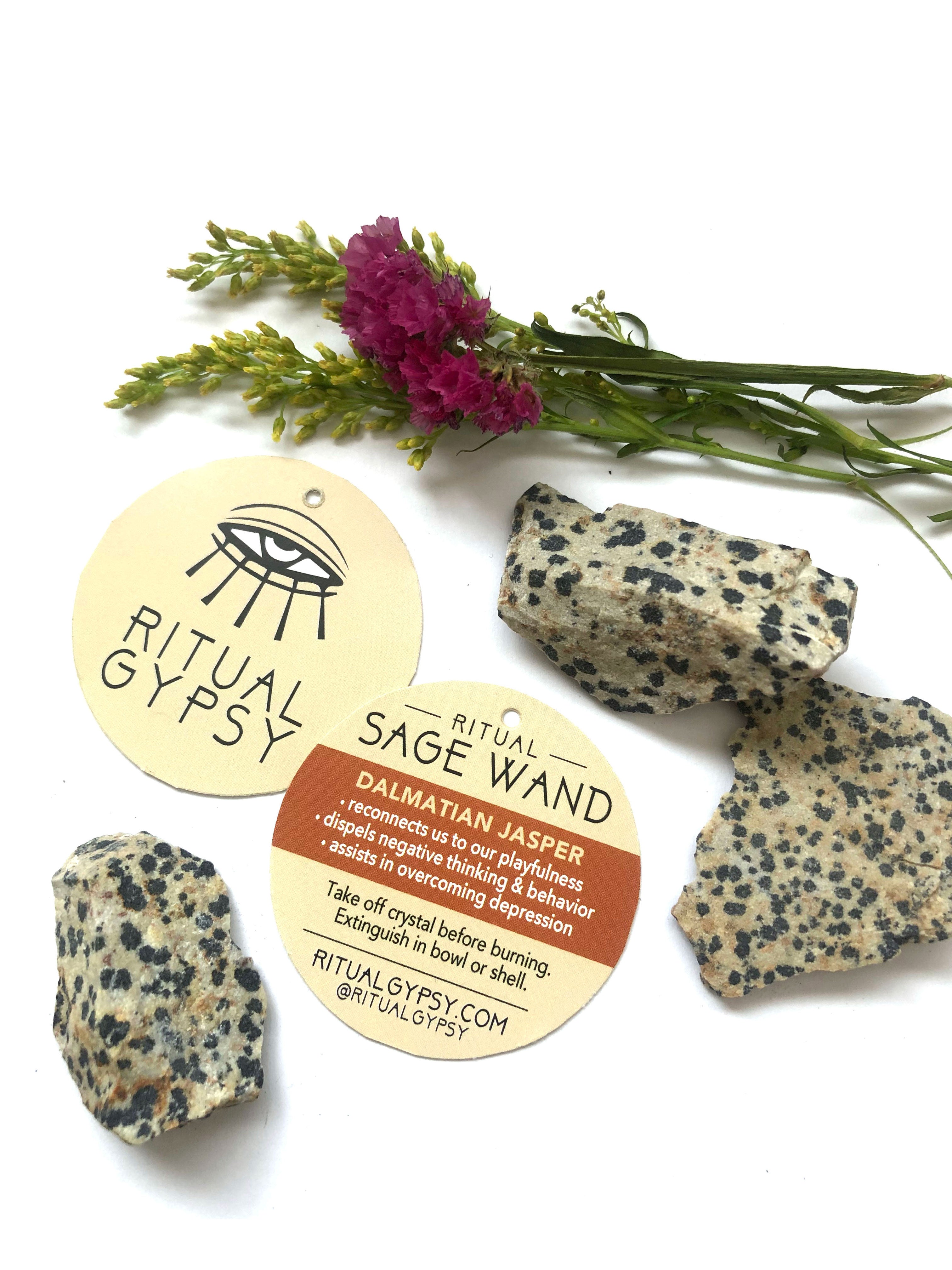 3 white with dark blue spots dalmatian jasper crystal stones and round ritual gypsy product tag on white surface