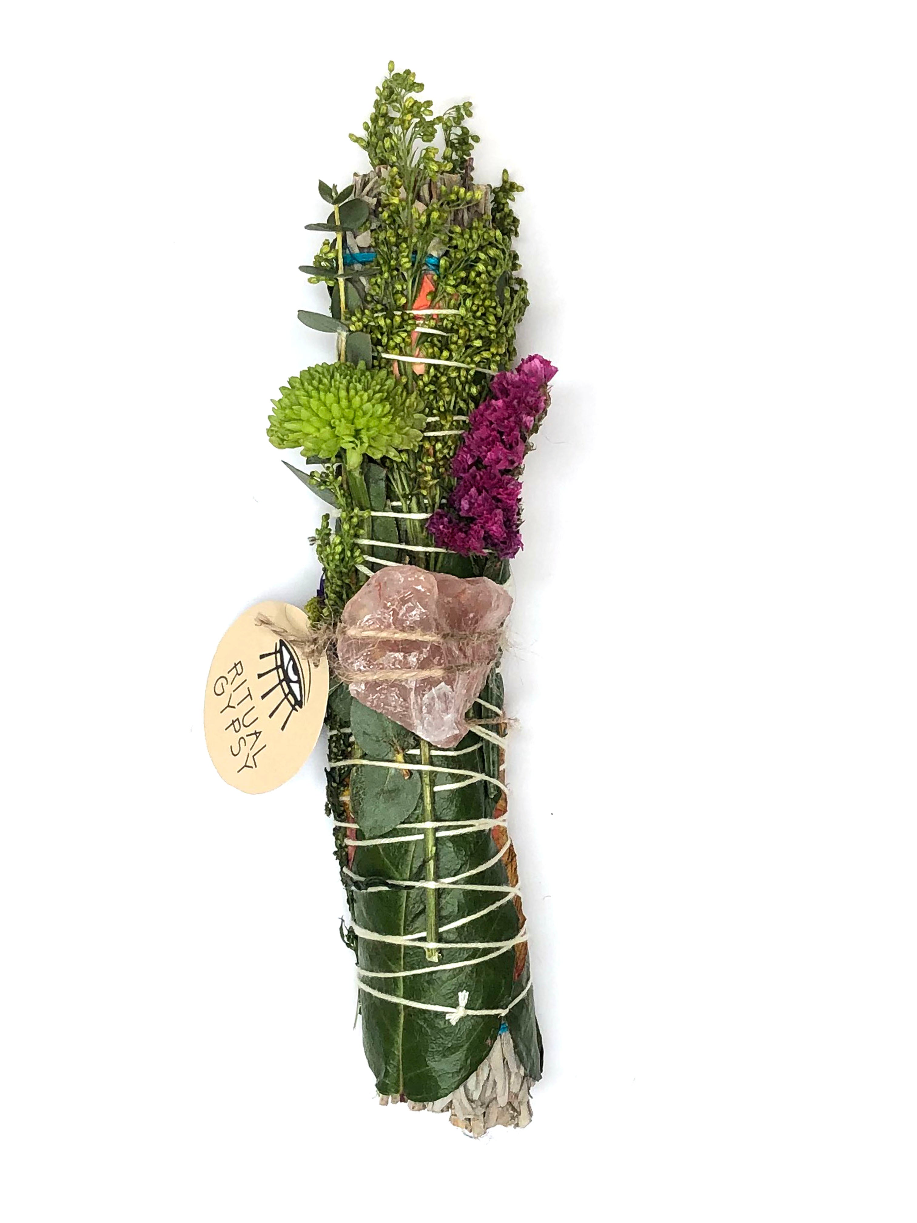 white sage smoke cleansing smudge bundle wrapped in florals with orange red strawflower and pink fire quartz crystal and round ritual gypsy product tag attached on white background