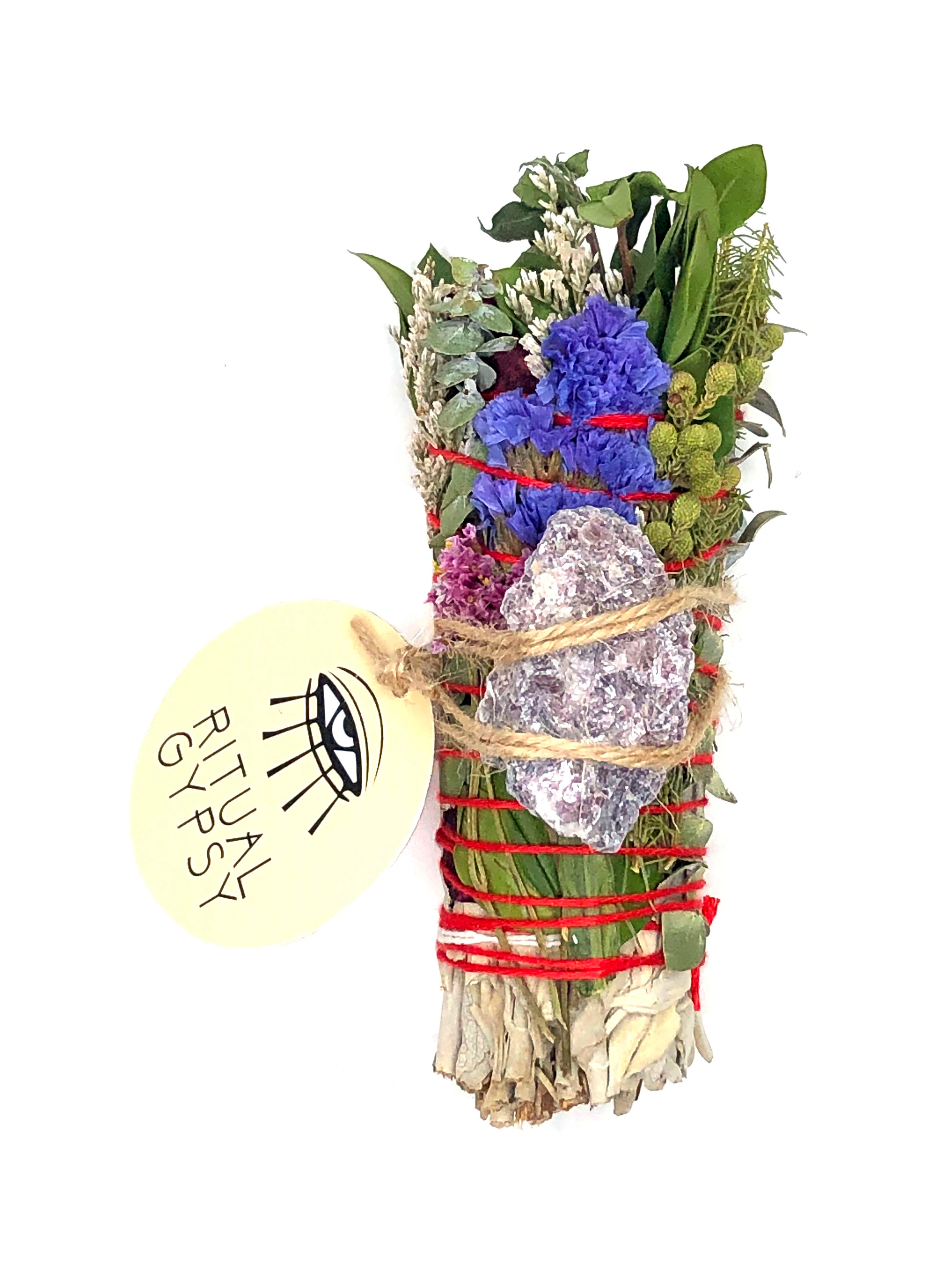 white sage smoke cleansing smudge bundle wrapped in florals with purple lepidolite crystal and round ritual gypsy product tag on white background