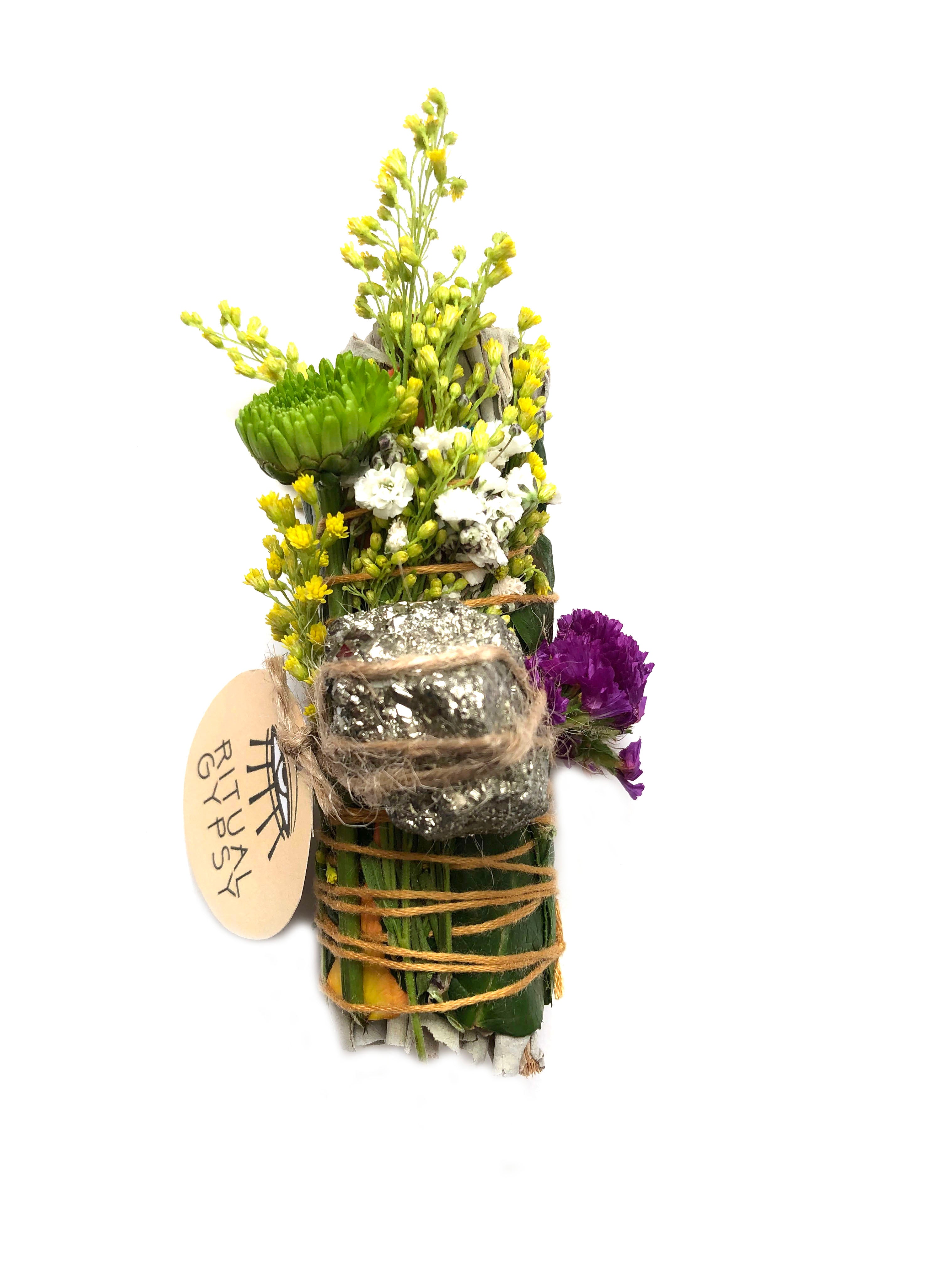 white sage smoke cleansing smudge bundle wrapped in rose petals and florals with gold pyrite crystal and round ritual gypsy product tag on white background