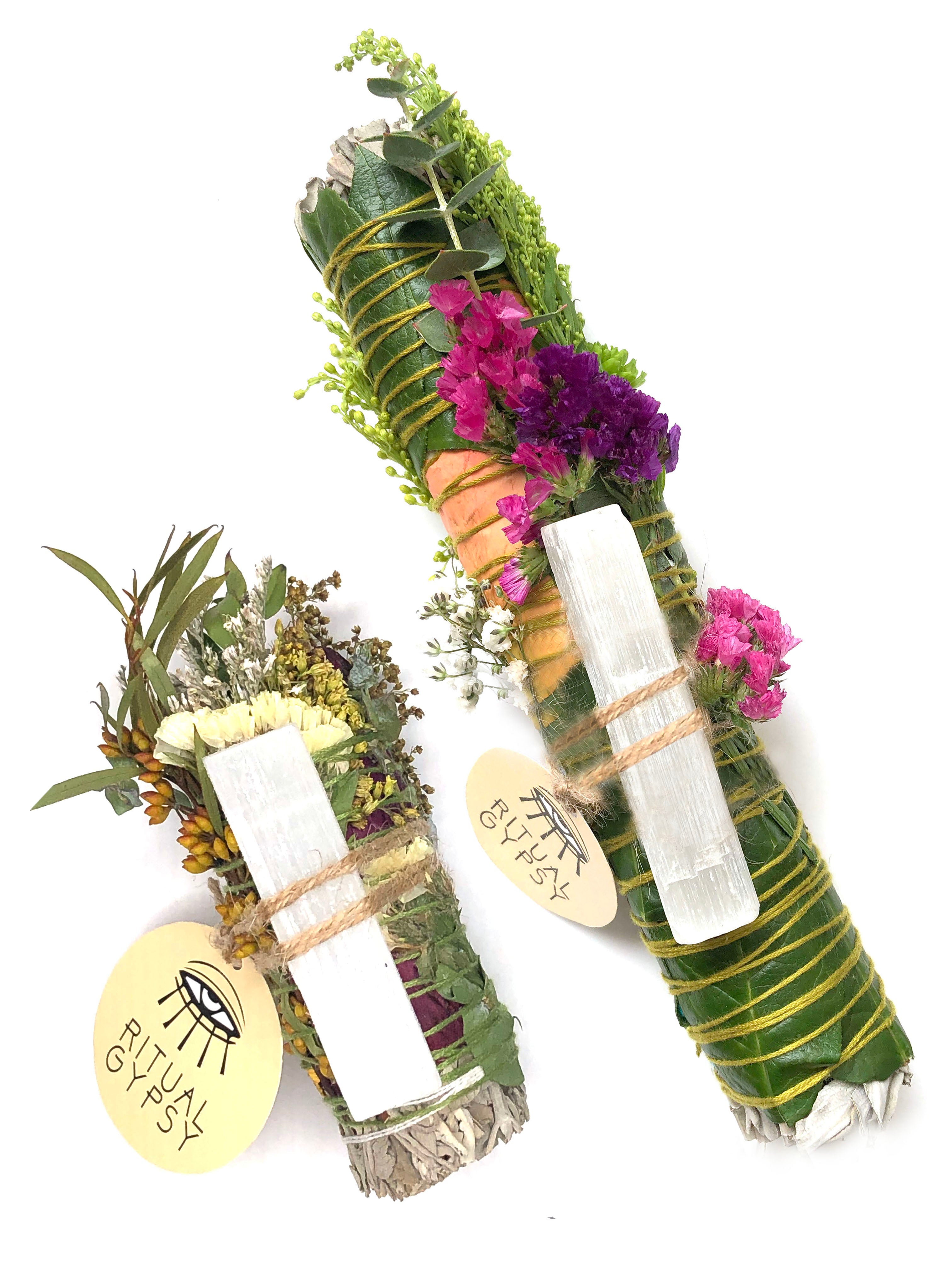 4" small white sage smoke cleansing smudge bundles with pink and purple statice and pink strawflower wrapped in florals with white selenite crystal and round product tag saying ritual gypsy attached