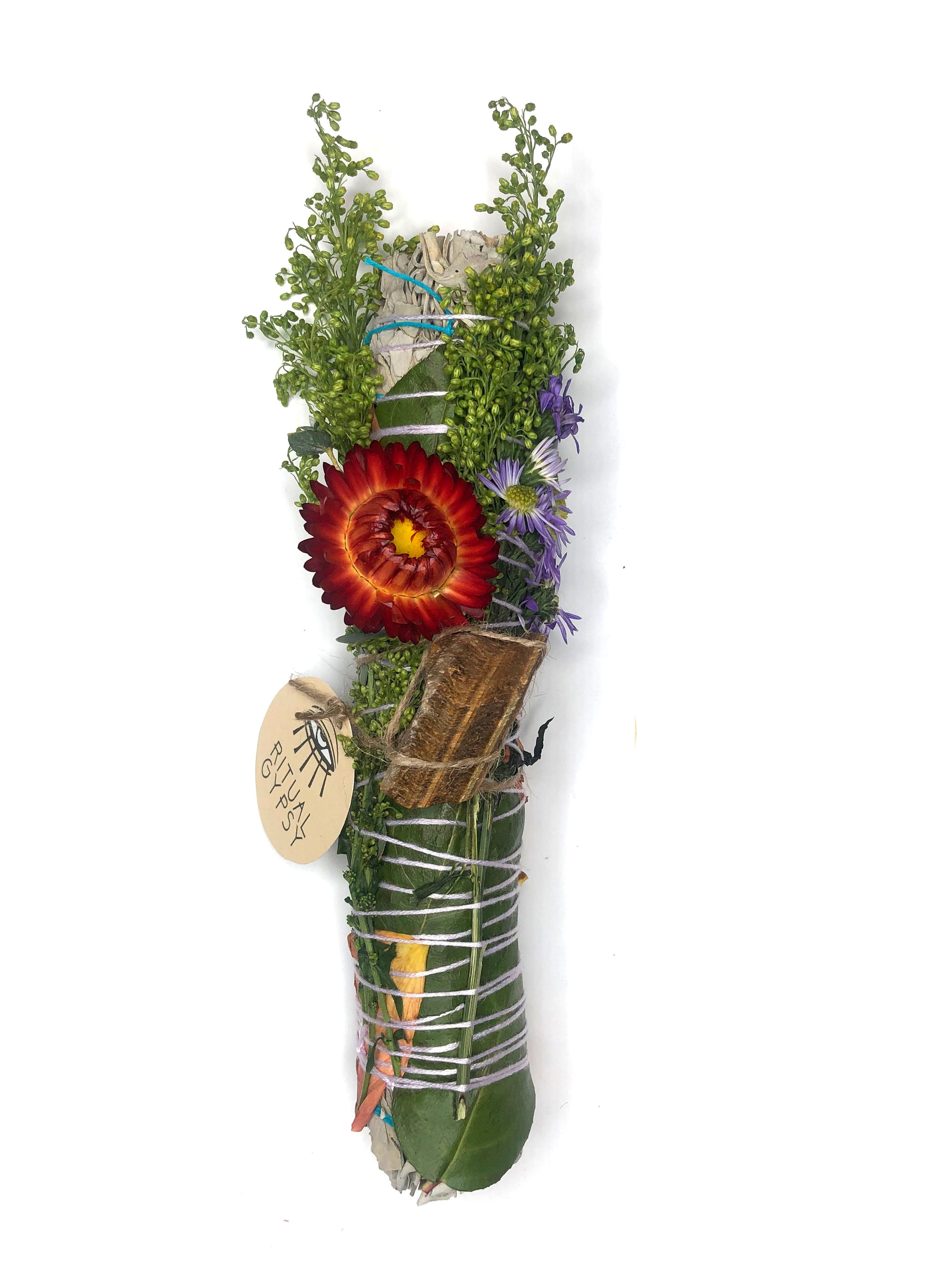 white sage smoke cleansing smudge bundle wrapped in florals with orange red strawflower and orange brown tan tiger's eye crystal stone and round ritual gypsy product tag attached on white background